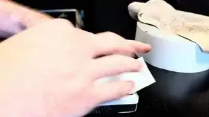 With one hand firmly grasping the iPod, pull the strip of tape upwards with your other to remove the Scroll Wheel from it's housing.