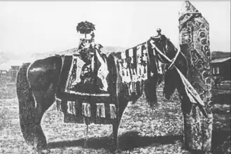 Тамчинский оленный камень с привязанной к нему «священной лошадью» (Диу). Начало XX века