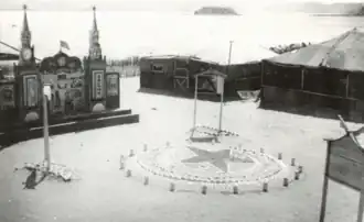 Вид на красочно оформленный вход в лагерь японских военнопленных (1945). Слева стена из кремлёвских башен с флагами и звёздами.