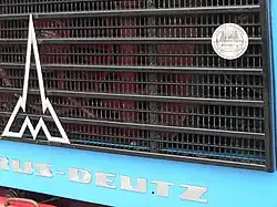 Эмблема «300&nbsp;000 без капремонта» на передней облицовке Магируса