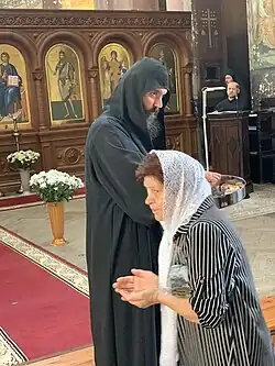 В Пантелеймоновском соборе. Наместник иеродиакон Давид (Сарсания) раздаёт святой хлеб, сентябрь 2021 года