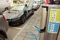 Процесс электрической зарядки автомобиля BMW i8 в Москве на уличной парковке. Оператором изображённой станции является ПАО «МОЭСК». Зарядка автомобиля на такой станции активируется с помощью специальной карты с чипом.
