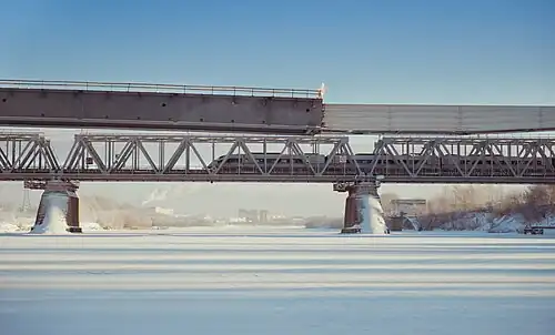 Железнодорожный мост, по которому проходят пути Октябрьской железной дороги. Перед ним ведётся строительство Западного моста.