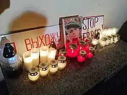 Фотография Романа Бондаренко окруженная лампадами и плакатами с надписью «Я выхожу» и «STOP TERROR».