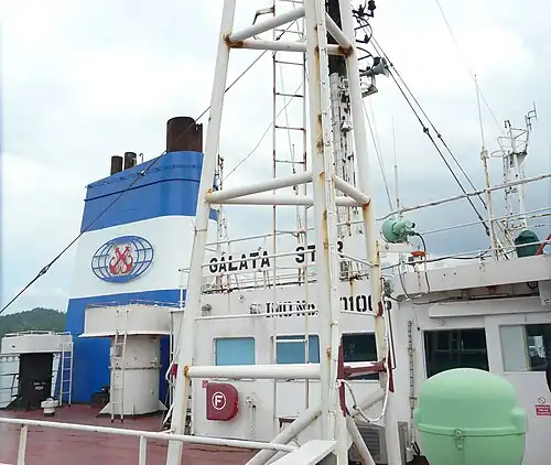Труба балкера Galata Star компании Pacmar Shipping. Видно, что на трубе ранее была другая эмблема, которая затёрта или срезана и закрашена, потому что ранее судно принадлежало другой компании. Со сменой компании меняют и эмблему на трубе судна