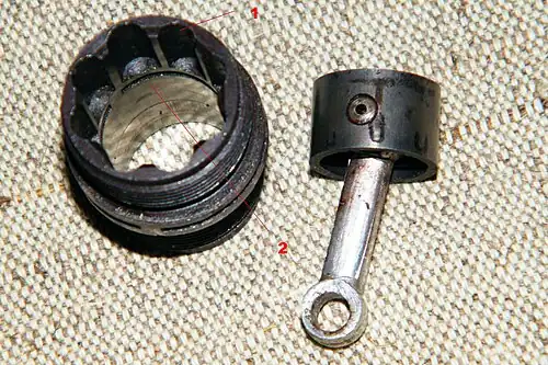 Цилиндр и поршень с шатуном двухтактного авиамодельного компрессионного двигателя «МК-12В» с фонтанной продувкой1 восемь продувочных каналов2 выпускные окна в стенке цилиндра