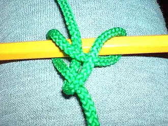 Шахтёрский узел, завязанный синтетическим шнурком вокруг карандаша