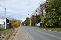 Слева расположен одноэтажный дом посёлка Старые Горки с адресом: ул. 1-я Калининградская, 2. Напротив него справа стоит девятиэтажный многоквартирный дом 1-го микрорайона Горок с адресом: ул. Карбышева, 47/1 (октябрь 2018)