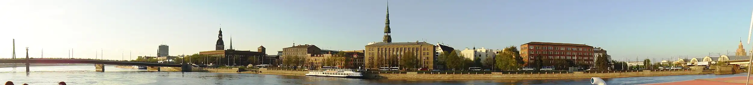 Набережная 11 Ноября. Слева&nbsp;— Каменный мост через Даугаву, правее него шпили Домского собора и церкви Св. Екаба. Здание в центре&nbsp;— Государственная земельная служба Латвии, за ней&nbsp;— шпиль церкви Св. Петра. Справа — Центральный рынок и здание Академии наук Латвии