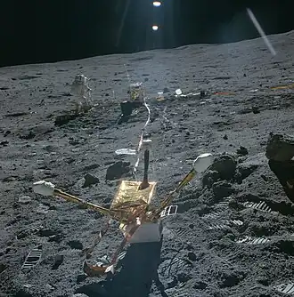 Магнитометр, на заднем плане&nbsp;— центральная станция ALSEP и радиоизотопный термоэлектрический генератор. Джон Янг делает подрыв последнего заряда