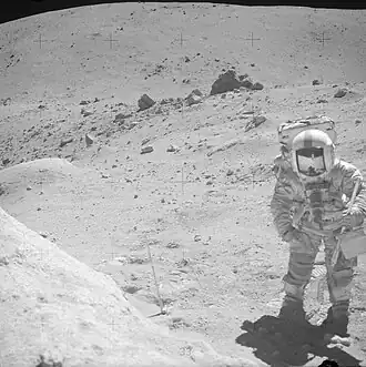 Джон Янг на Station 11. Позади него и чуть левее&nbsp;— скала House Rock. На заднем плане&nbsp;— гора Смоки