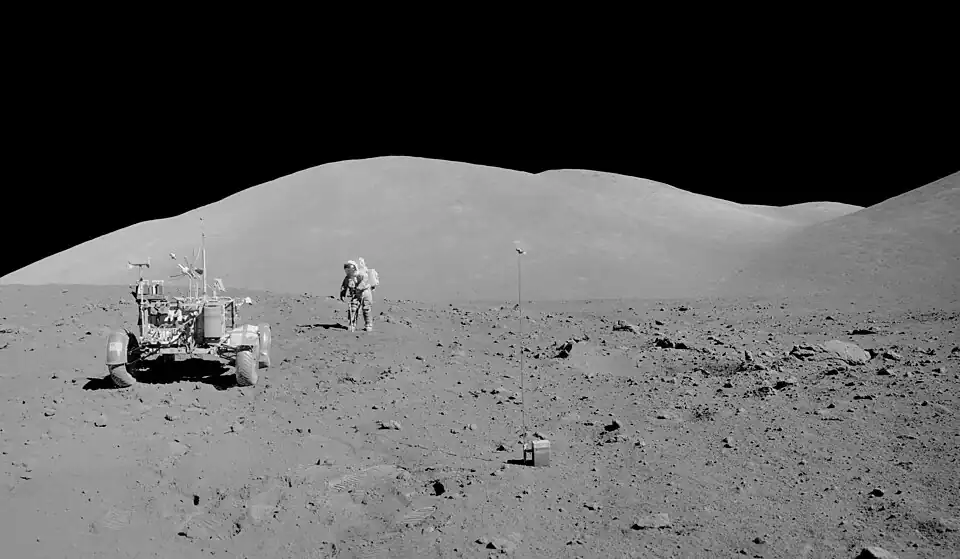 Сернан с двойной трубкой-пробоотборником на Station 9. На переднем плане в центре&nbsp;— заряд взрывчатки