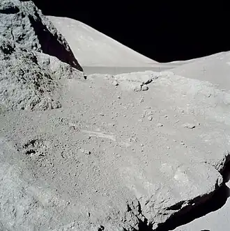 Фрагмент скалы, с которого Сернан собрал грунт. Слева отпечаток руки астронавта, правее&nbsp;— борозды, оставленные мешочком для образцов