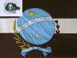 Флаг Примейру-ди-Маю: сине-коричневое полотнище с гербом, луной, звездой и девизом «Sempre ama e confia».