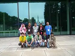 Десять человек стоят лицом вперед, в две шеренги по пять человек. В первом ряду сидят пятеро подростков. За ними&nbsp;— пятеро взрослых.