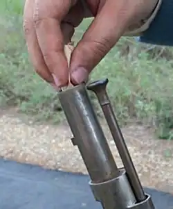 Бо́льшая часть пороха высыпается в ствол, после чего в ствол опускается пуля вместе с бумажной обёрткой патрона, которая используется в качестве пыжа.