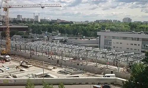 Июнь 2015 года. Сооружение крыши станции. Между платформами&nbsp;виден временный защитный навес, в котором следуют поезда