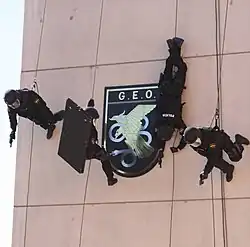 Бойцы GEO на фоне эмблемы спецподразделения