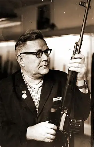 Е. Ф. Драгунов держит в руках снайперскую винтовку СВД