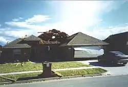 EF1 damage example -- Sections of roofing are removed from the home, leaving the internal decking exposed.