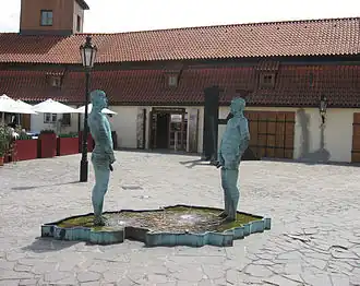 Вход в музей Кафки. Перед ним — скульптурная композиция-фонтан Давида Черного, изображающая двух мужчин, мочащихся на карту Чехии.