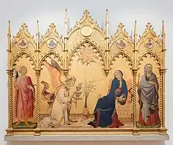  An altarpiece with a golden background and a frame surmounted by five richly carved Gothic pediments. Centre, the Virgin Mary, who has been reading, turns in alarm as the Angel Gabriel kneels to the left. The angel’s greeting «Ave Maria, Gratia Plena» is embossed on the gold background. The figures are elongated, stylised and marked by elegance. There are saints in the side panels.