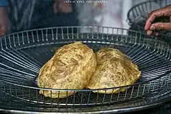 Тонкий хлеб обжаривают в масле и едят с картофельным карри из нута и сладким пудингом