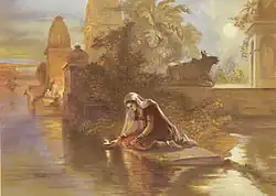 Индийская женщина опускает зажжённую лампаду на воды Ганга