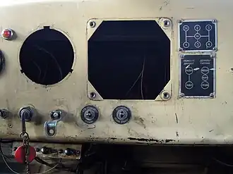 Середина приборной панели, отличия от КрАЗ-255&nbsp;— нет манометра воздуха в шинах, на диаграмме раздатки не обозначен рычаг включения переднего моста