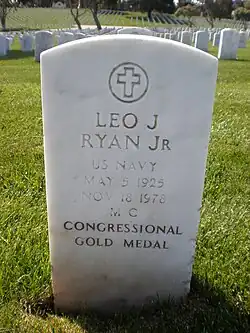 A white-colored tombstone stands in the middle of a cemetery. «Leo J. Ryan Jr» is engraved on it.