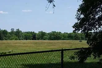 Вид на огороженную территорию в 2012&nbsp;году. В 1970-х на этом месте стояли жилые дома и начальная школа