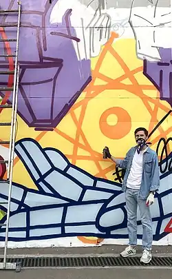 artist Misha Most standing near his new mural