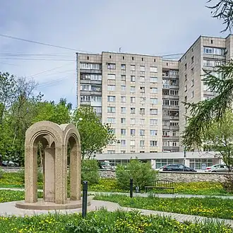 Современный вид места происшествия. На заднем плане — жилое здание, на первом этаже которого располагался клуб. На переднем плане — сквер Уральских Добровольцев и памятник жертвам пожара