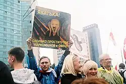 Изображение протестующего в сентябре 2020&nbsp;года, который держит в руках плакат, на котором изображен Лукашенко в стиле картины Мунка «Крик», а подпись гласит «Ябатька! Сколько проституток, наркоманов и овец!»