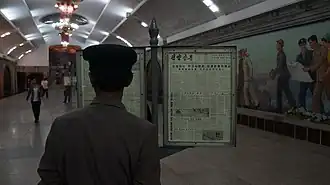 Житель КНДР читает номер газеты на станции метро «Пухын»