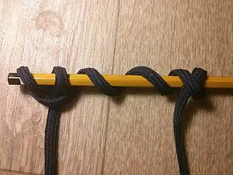 Стопорный узел, который завязан обувным шнурком на карандаше