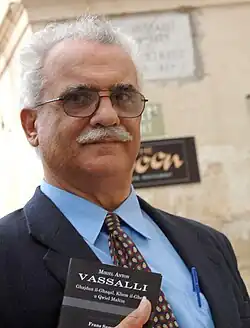 Франс Саммут держит в руке свой перевод собрания мальтийских пословиц Вассалли.