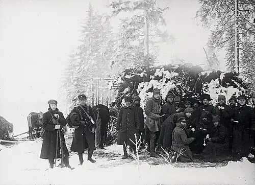 Обезоруженные воины СЗА (справа), которых интернируют в Советскую Россию, едят в лесу под охраной эстонских солдат (слева), февраль 1920 года