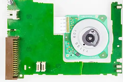 Плата управления и двигатель. На шпинделе двигателя имеется два штифта: центральный и подпружиненный боковой. Двигатель —&nbsp;синхронный, трёхфазный. Также в него встроен датчик положения — вместо индексного отверстия в самом диске, как это сделано в 5¼″ и 8″ дисках.