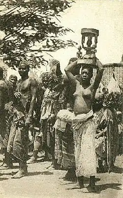 1908 год. Молодая девушка с деревянной статуей божества на голове