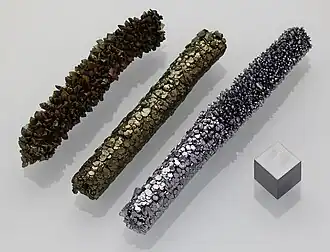 Чистый ванадий (брусок справа и куб) и два его оксида (бруски слева). Пластичный металл серебристо-серого цвета.