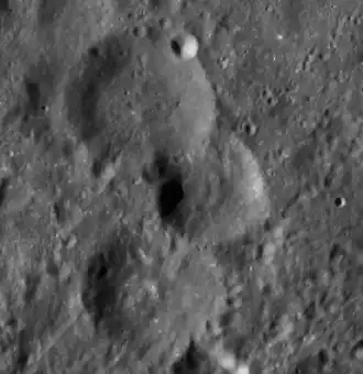 Снимок зонда Lunar Reconnaissance Orbiter. Сверху вниз кратер Волков, сателлитный кратер Волков J, кратер Ландер.