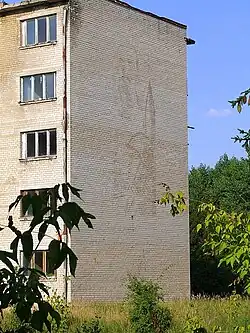 Дом в военном городке, на стене изображены портрет В. И. Ленина, часть ракеты, и воин ВС СССР, 2007 год.