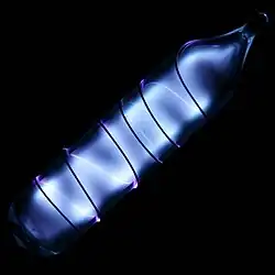 Glass tube shining blue light with a wire wound over it